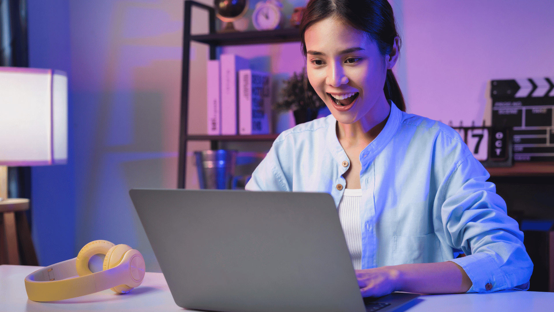 Excited woman looking at her laptop while learning how to write a marketing email.