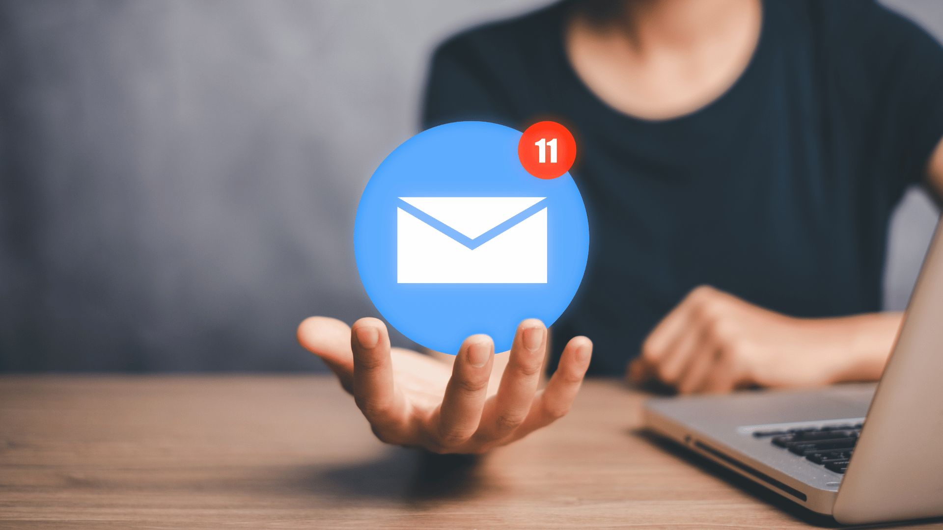 Person holding an email notification icon while learning how to write a marketing email.